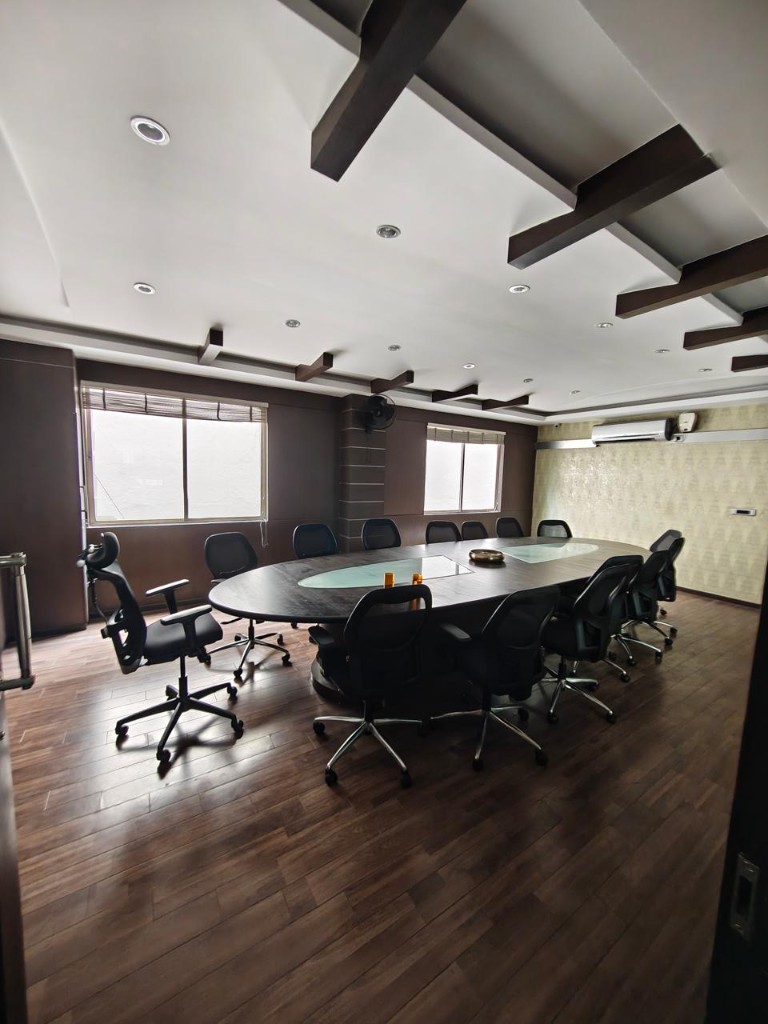 Meeting room with an oval conference table and mesh chairs